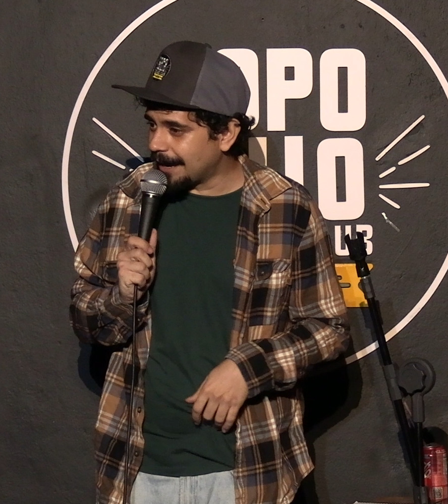 Illan Carvalho no palco segurando um microfone